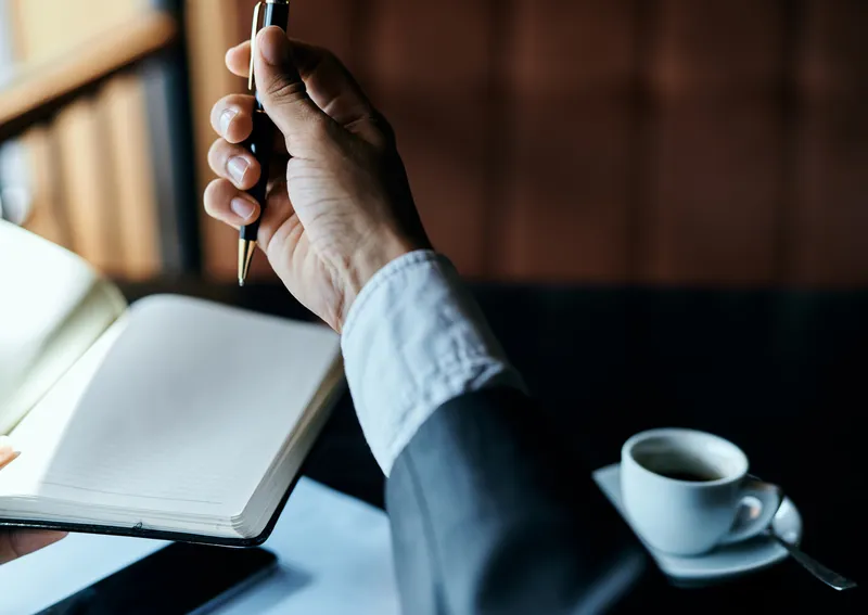 Бизнесвумен в кафе с книгой на столе, документами и чашкой кофе, работа, образ жизни
