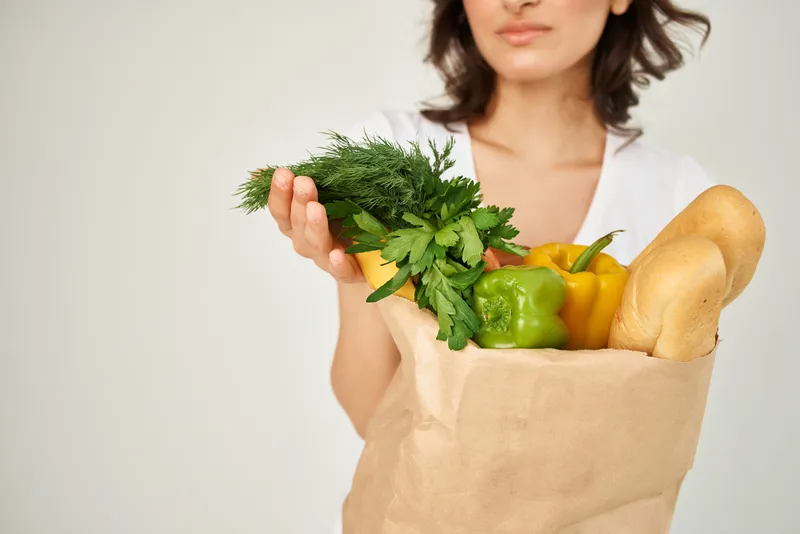 Женщина с пакетом овощных продуктов, крупный план, обрезанный вид