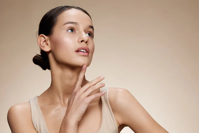 A serene model showcasing a natural beauty pose with soft lighting, embodying a sense of tranquility and confidence in a minimalist setting