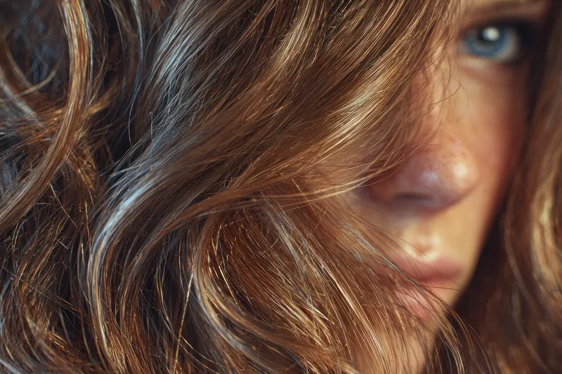 Мягкое, интимное настроение с естественным светом и малой глубиной резкости, подчеркивающее текстуру волос, переливы цвета и спокойную тишину личного момента
