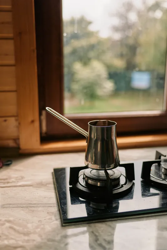 Coffee scene with a moka pot on a gas stove in a cozy kitchen, capturing aroma warmth and morning brew in a domestic setting