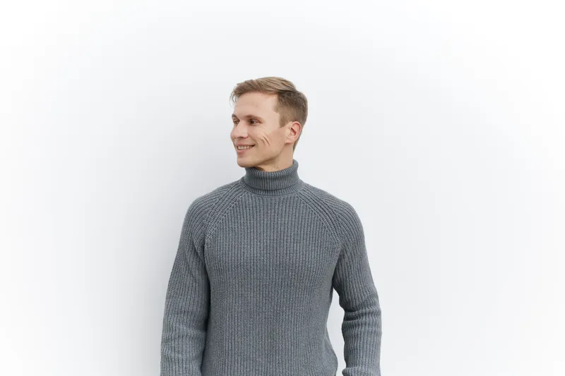 smiling caucasian man wearing gray knitted sweater look side standing isolated white background casual style digital nomad concept