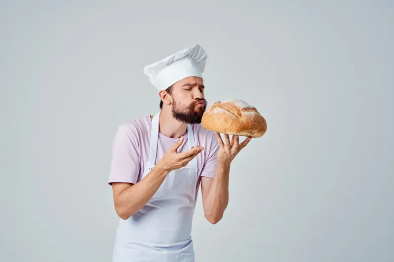 Эмоциональный повар с хлебом в руках, выпечка, кулинария
