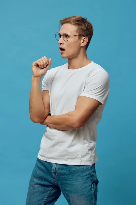 surprised young caucasian man wear glasses white t-shirt jeans look aside open mouth blue background studio portrait emotion concept