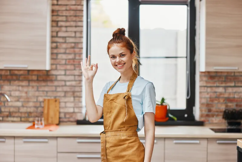 Веселая женщина на кухне жестикулирует руками