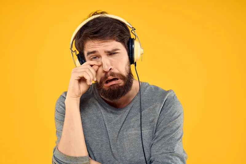 Мужчина в наушниках на желтом фоне