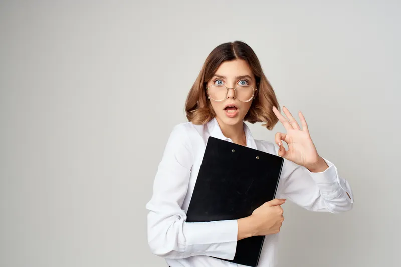 Женщина в костюме на официальной работе в офисе, эмоции успеха на светлом фоне