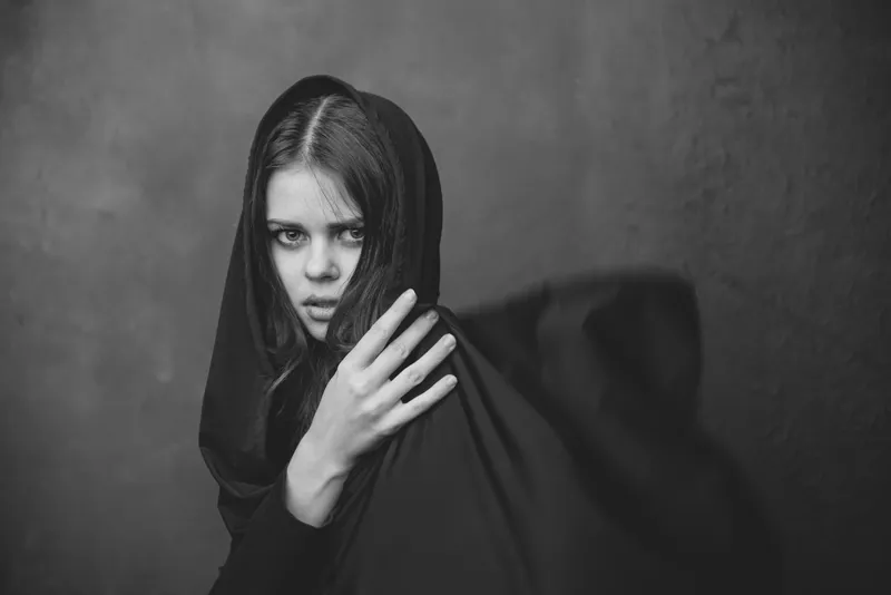 Чёрно-белая фотография молодой женщины с тканью на голове, кадрированный крупный план