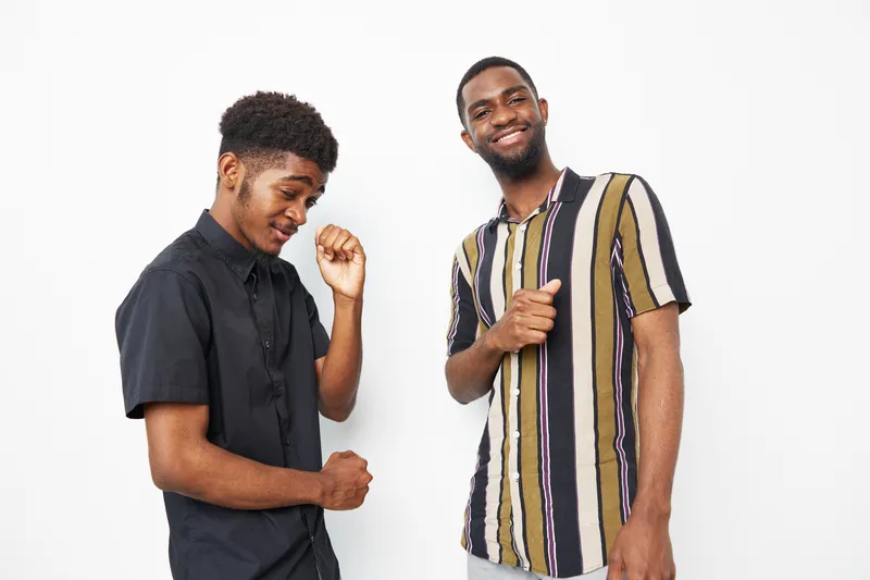 Happy African American men enjoying a fun moment together, showcasing friendship and joy. Perfect for themes of diversity and positivity in social settings.