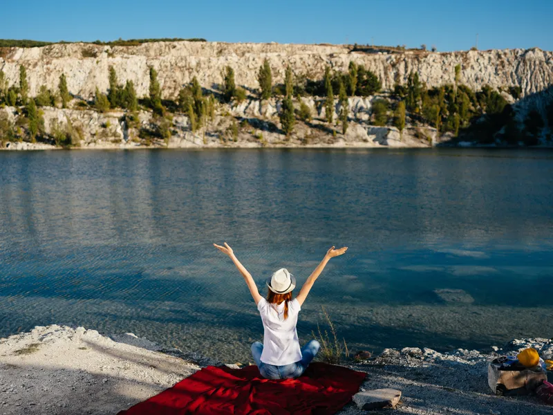 Женщина на природе любуется пейзажем во время летнего отдыха