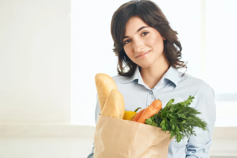 Весёлая женщина с пакетом продуктов, здоровая еда, овощи, домохозяйка