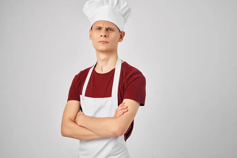 Мужчина в белом фартуке работает поваром на кухне, отражение образа жизни