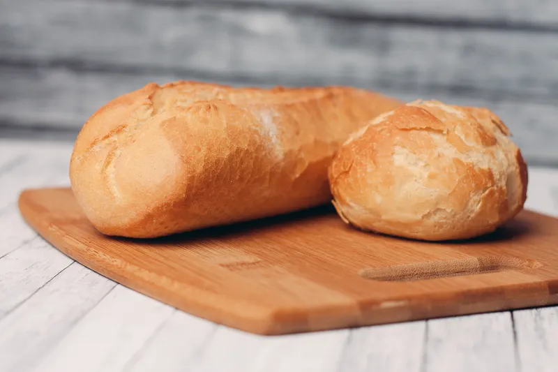 Буханка хлеба с булочкой, свежая выпечка, домашняя кулинария, деревянная доска, свежий вкус