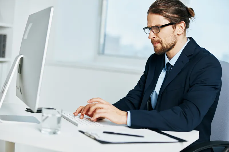 Мужчина в костюме, официальное лицо, работает за компьютером
