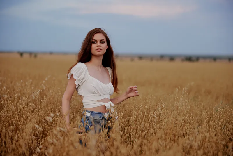 Женщина гуляет по полю летним днём, наслаждаясь свободой