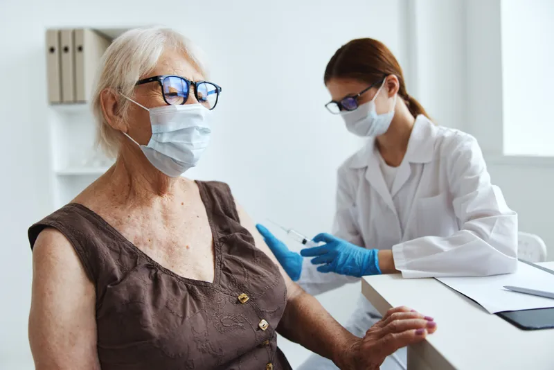 Врач со шприцем делает пациенту инъекцию вакцины, паспорт вакцинации