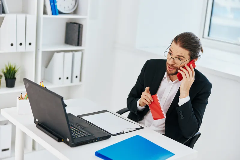 Менеджер работает с документами в офисе за ноутбуком, используя технологии