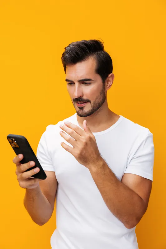 Удивлённый мужчина с зубастой улыбкой держит смартфон, копируя пространство