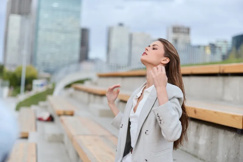 Confident businesswoman in a stylish light gray blazer, showcasing elegance against a modern city backdrop, embodies professionalism and empowerment.