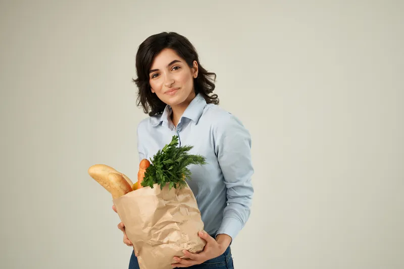 Улыбающаяся женщина с пакетом продуктов, супермаркет, образ жизни