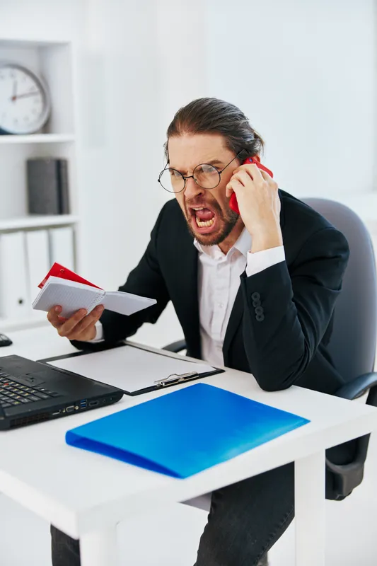 Бизнесмен с документами работает в офисе за ноутбуком, отражена его повседневная жизнь