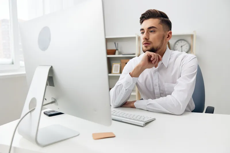 Офисный работник-бизнесмен в белой рубашке работает с технологиями