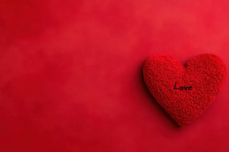 Ярко-красное сердце с надписью «Love» на насыщенном красном фоне вызывает чувства романтики, единения и душевного тепла