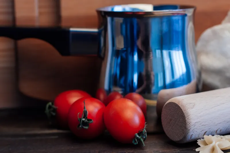 Приготовление итальянской кухни: мука, продукты на кухонном столе, помидоры черри