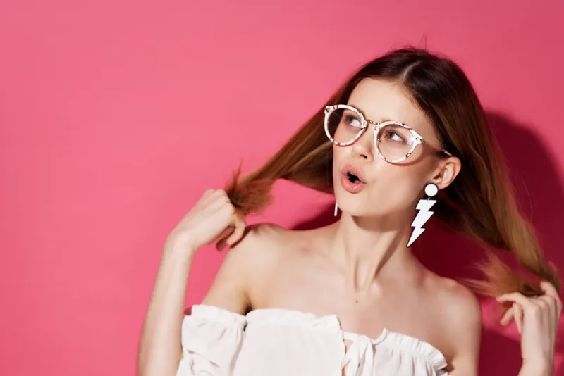 Привлекательная женщина с ярким макияжем в белом платье на изолированном фоне