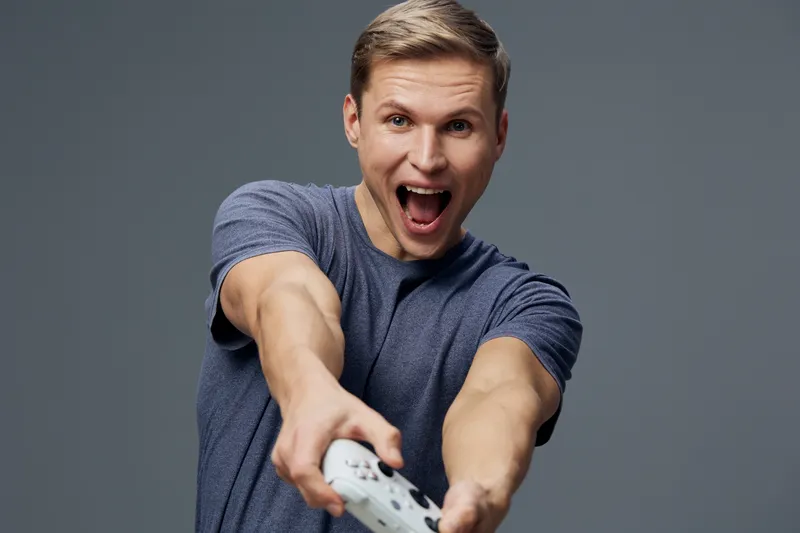 excited young caucasian man holding game controller play video games technology entertainment concept