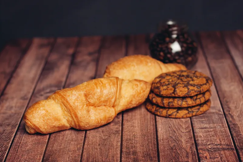 Чашка кофе, печенье, сладости на деревянном столе, закуска
