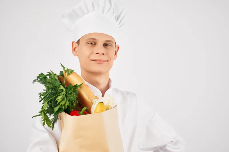 Шеф-повар с упаковкой свежих продуктов на кухне