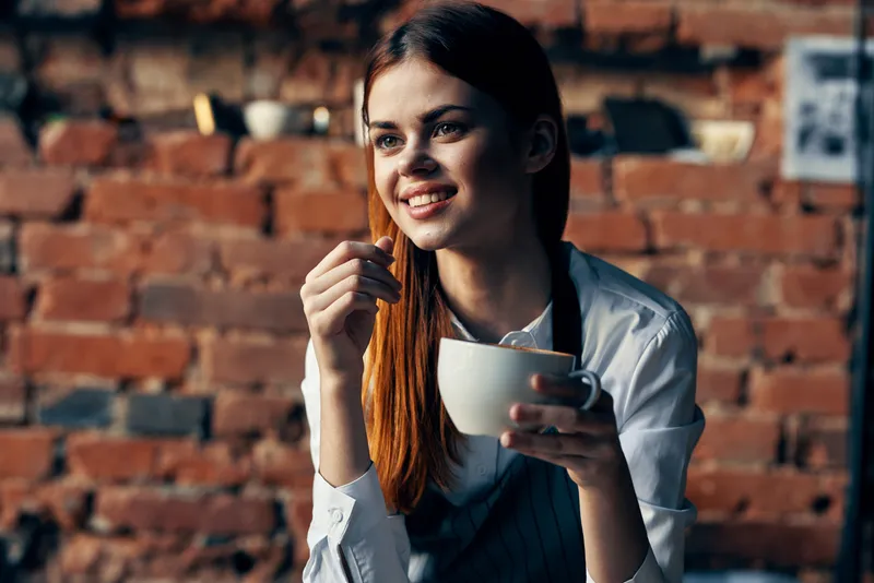 Женщина с чашкой кофе возле стола, официант, сервис, работа профессионалов