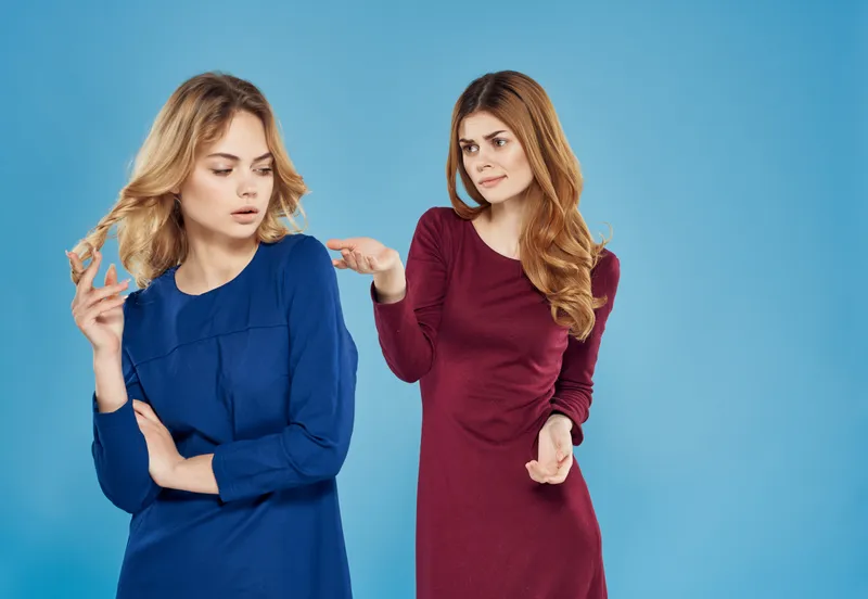 Две элегантные женщины в платьях стоят рядом
