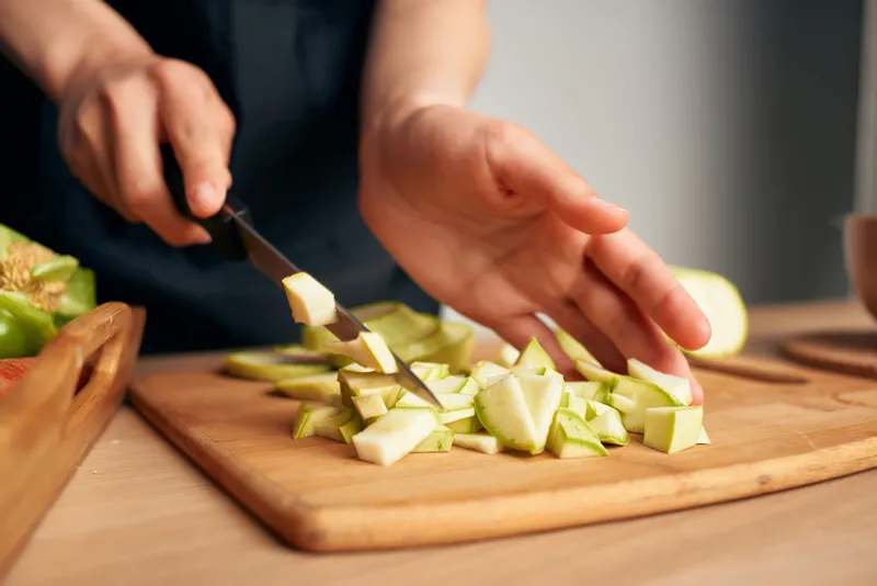 Нарезка овощей на кухне, приготовление здоровой пищи