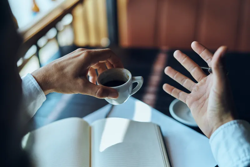 Бизнесвумен в кафе с книгой на столе, документы, чашка кофе, работа, образ жизни