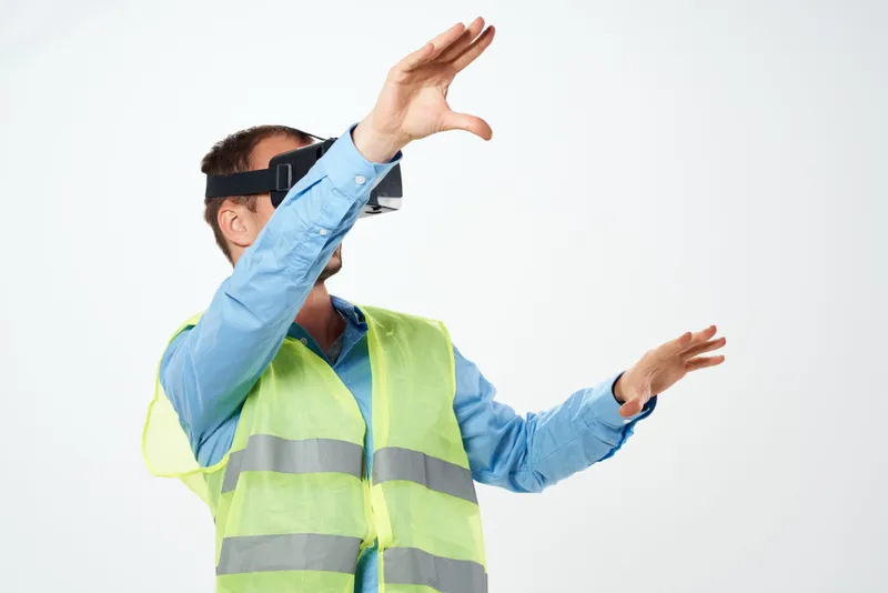 Мужчина в строительной униформе работает с VR-очками