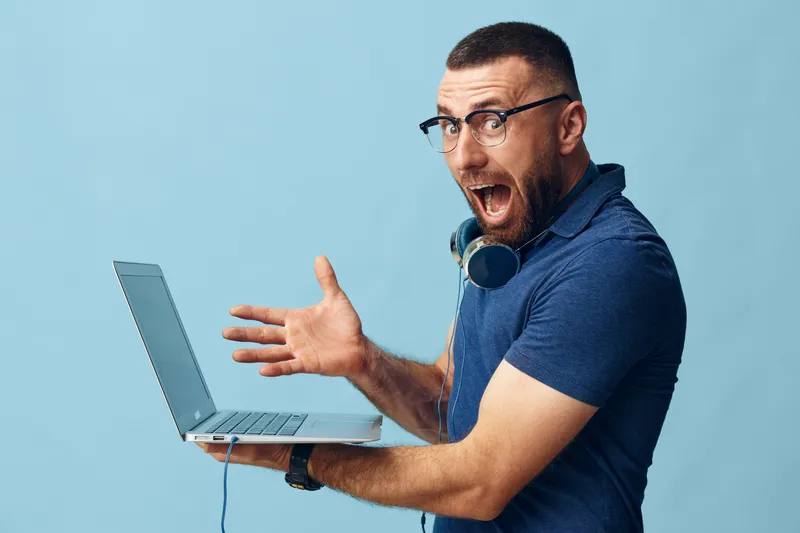 Мужчина общается онлайн, работая за ноутбуком в офисе