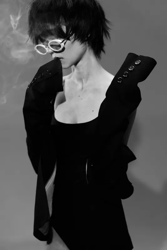 Stylish woman in black dress and white sunglasses in black and white with smoky atmosphere and modern look