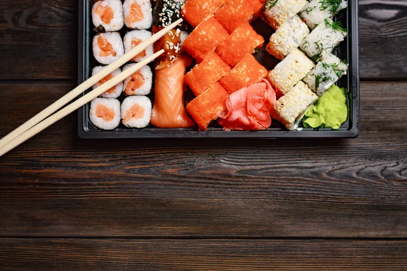 Роллы с морепродуктами на деревянном столе и палочки для еды