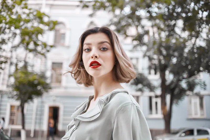 Весёлая женщина на улице возле дерева, развлекается