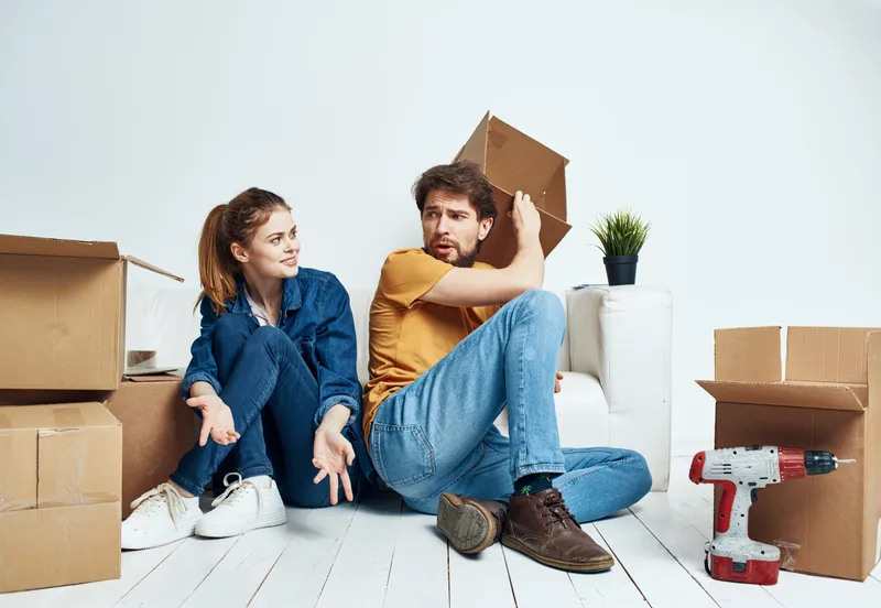 Влюбленная пара переезжает, рядом с ними инструменты и цветок в горшке, мужчина и женщина