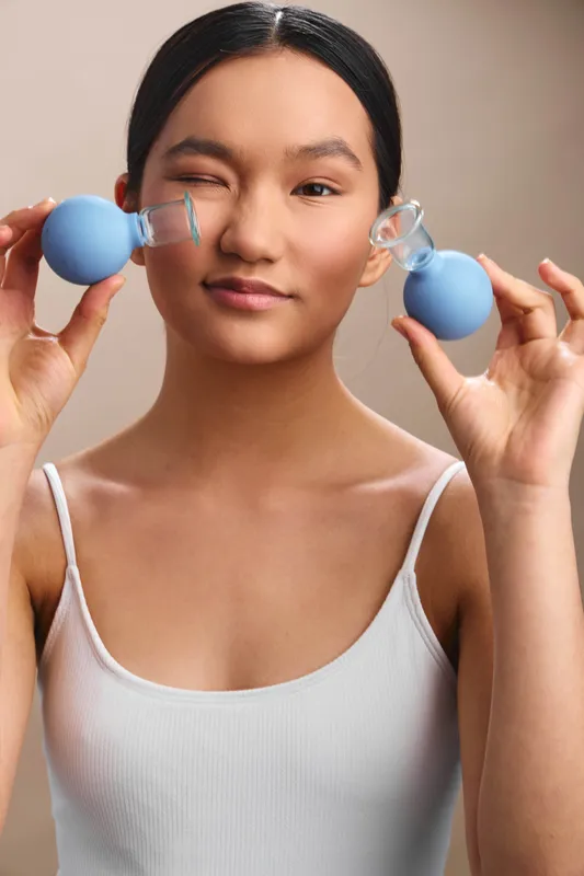Asian woman portrait demonstrates facial wellness with nasal devices, close up, soft lighting, calm mood, emphasizing everyday self care and gentle personal care routine.