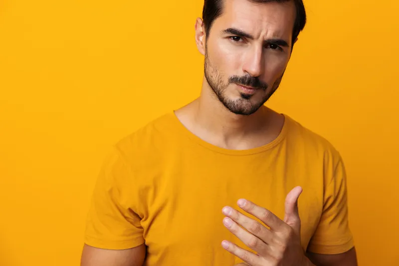 Привлекательный мужчина в студии на жёлтом фоне