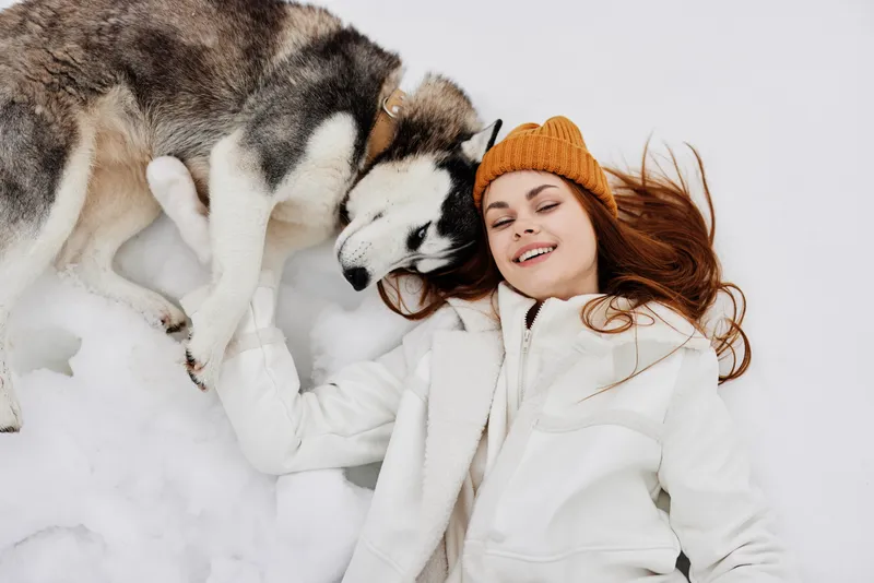 Портрет женщины на улице в поле зимой, гуляющей с собакой