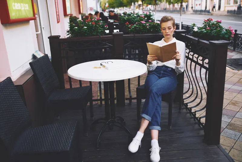 Студент с книгой в руках на улице, отдых в городе, лето, общение