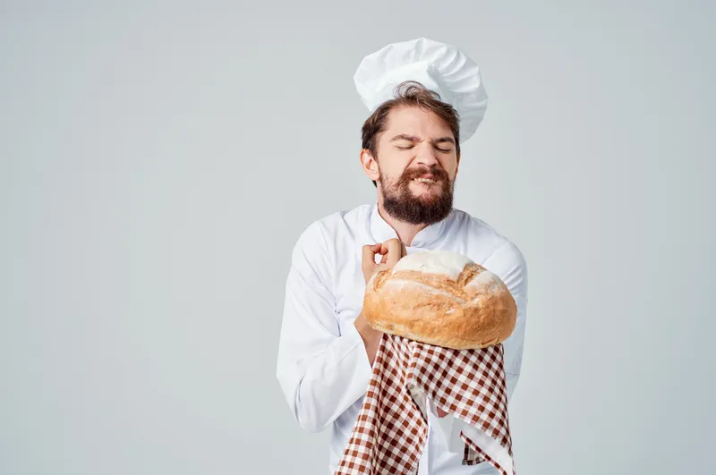 Повар-мужчина с хлебом в руке, кулинарная индустрия