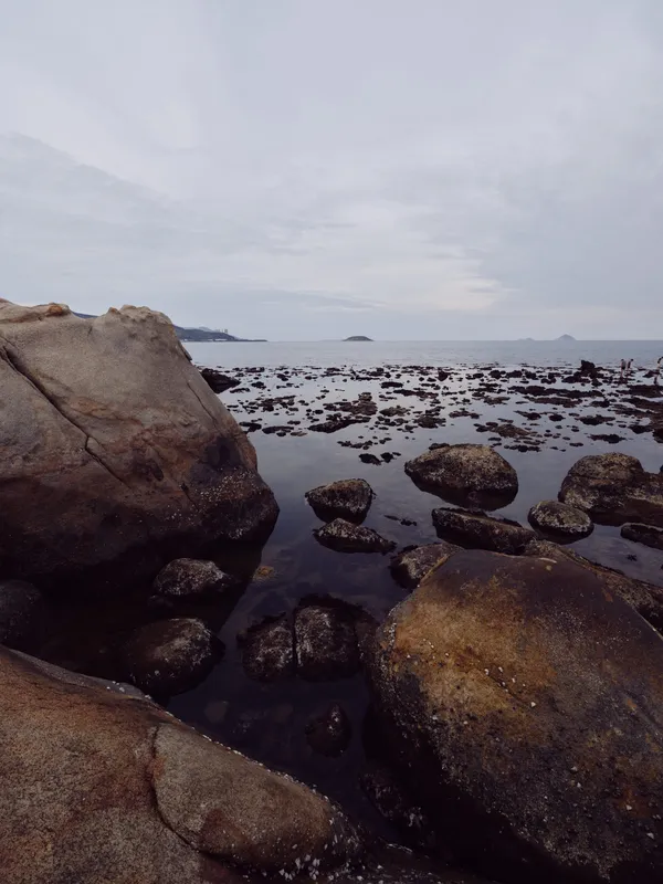 Tranquil coastal landscape featuring rugged rocks and calm water, reflecting a serene atmosphere for a peaceful getaway, ideal for nature lovers and relaxation