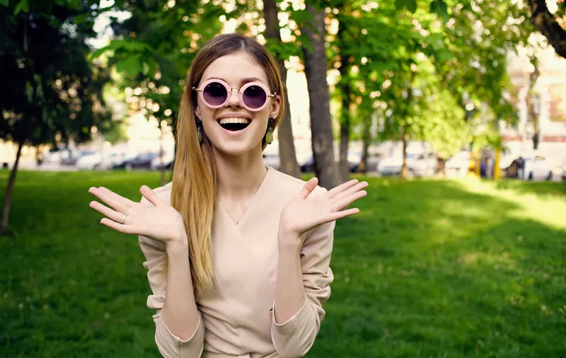 Веселая женщина отдыхает на природе, лежа на зеленой траве
