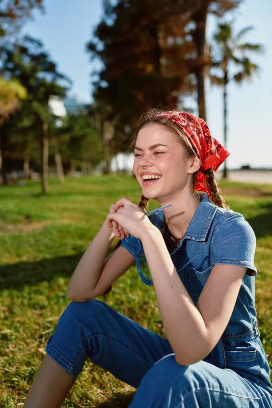 lifestyle woman in modern boho-western denim street style smiling outdoors with film color, casual fashion and natural sunlight, happy young adult female